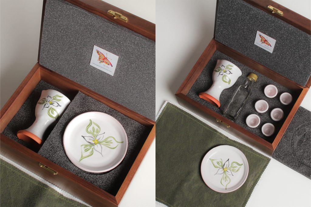 Walnut box (made in USA from sustainable sources), custom made to fit the set, with hard foam on the inside bottom of the box, which is carved to hold the set. Soft foam lines the lid and supports the plate to cushion the ceramics for travel.