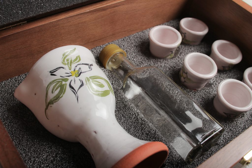 Glass wine bottle with spill proof cap (Glass is cleanable, and unlike the plastic ones you have used, glass will not stain over time). The glass bottle is dishwasher safe. If you do find a discoloration after many uses, swish a few grains of uncooked rice with a little water around in the bottle. They scrub it clean! Handwash the plastic lid.